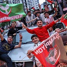 Fans celebrating Amedspor's success in the Super League with flags and enthusiasm.