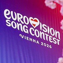 Eurovision Song Contest Vienna 2026 promotional banner with pink cherry blossoms in the foreground.