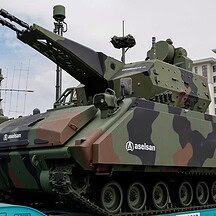 A powerful military tank with advanced weaponry and camouflage, displayed at a public event in Istan.