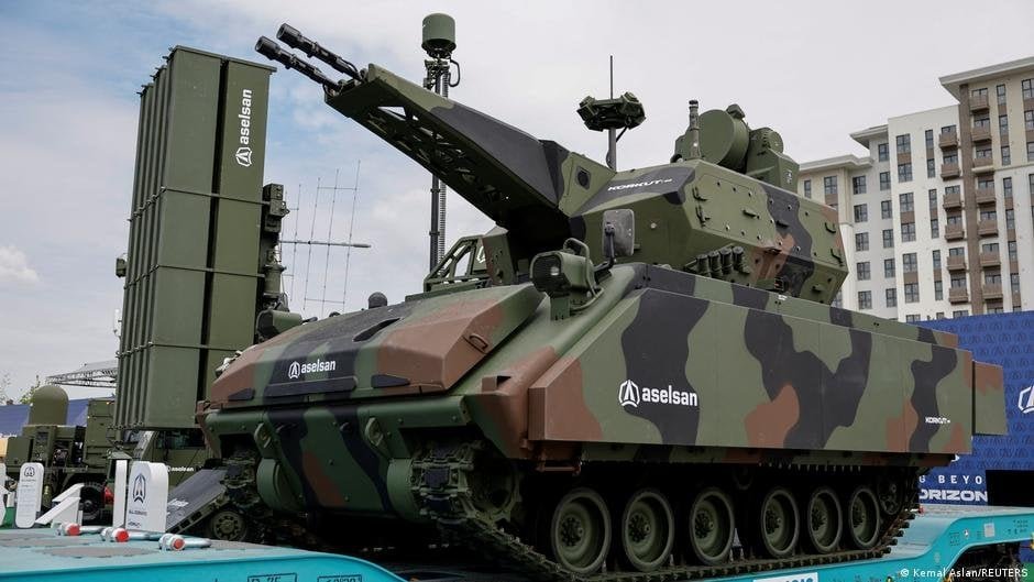 A powerful military tank with advanced weaponry and camouflage, displayed at a public event in Istan.